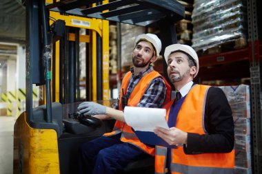 Ambar yöneticisinin ve stok sayım yapma forklift kamyon sürme yükleyici portre