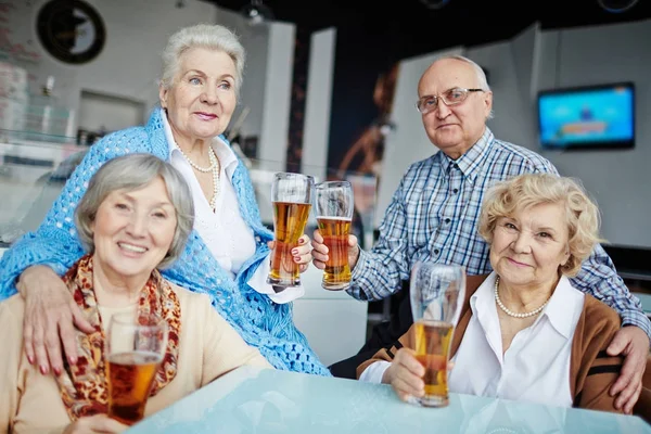 Vier Senior Vrienden Opknoping Pub Zitten Aan Tafel Met Bierglazen — Stockfoto