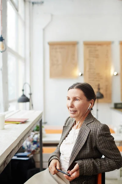 Mujer Madura Aspecto Elegante Auriculares Sentados Ventana Panorámica Absorbida Sus — Foto de Stock