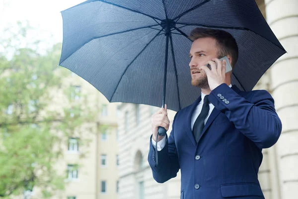 Elegantní Muž Obleku Mluví Smartphone Pod Deštníkem — Stock fotografie