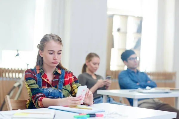 Tienermeisje Met Smartphone Sms Klas Door Bureau — Stockfoto