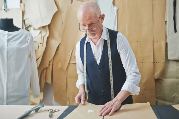 熟练的老裁缝在工作室做衣服的画像 — 图库照片
