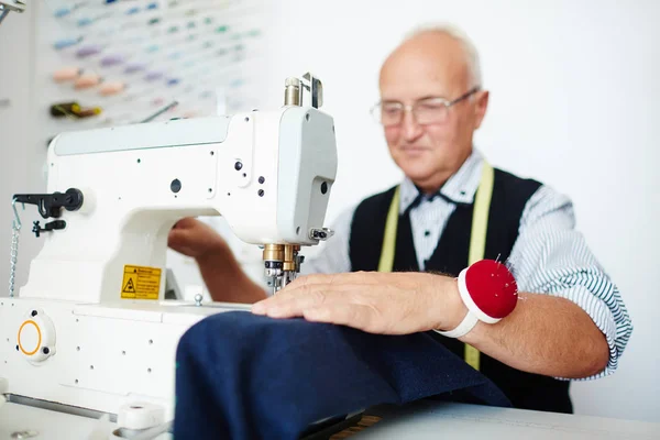 传统工作室缝纫机中微笑老裁缝的肖像 — 图库照片