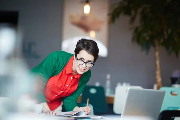 Kvinna Med Penna Över Öppna Tidningen Tittar Kameran — Stockfoto