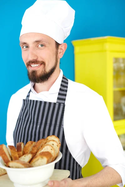 Улыбающийся Пекарь Держит Тарелку Нарезанным Хлебом — стоковое фото