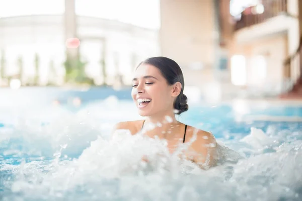 Opgewonden Vrouwelijke Lachen Terwijl Het Warme Water Spatten Tijdens Spa — Stockfoto