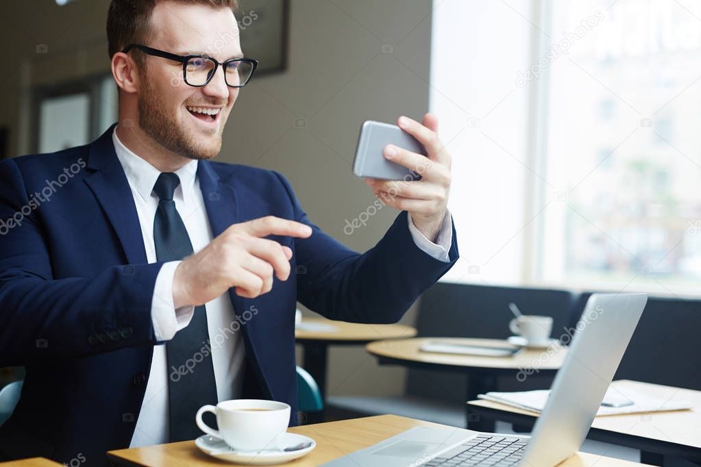 Businessman with gadgets communicating through video-chat in cafe