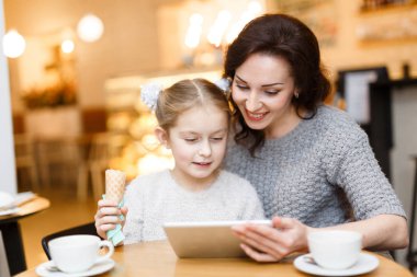 Dondurma ve touchpad içinde bir şey online izlerken annesi ile kız