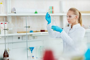 Renkli kontrollerimiz bagajinda sıvı test tüpleri karıştırma modern laboratuvarda çalışan güzel sarışın kadın portresi