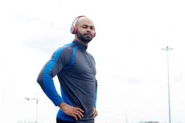 Etkin adam kalçalarına ellerini tutarak kulaklık