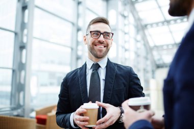 Gülümseyen işadamı içki yaparken ortağı için dinleme