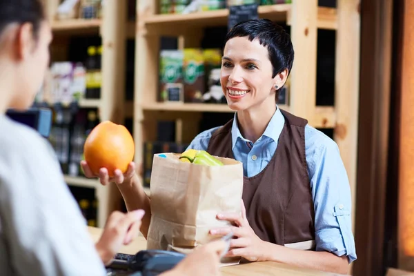 Bijwonen aan klant in supermarkt — Stockfoto