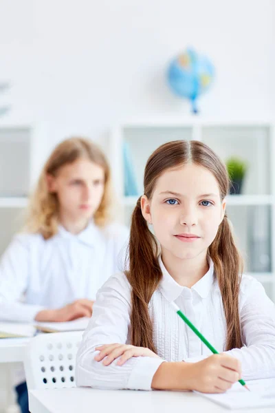 女孩与蜡笔和她的同学在背景速写在课上 — 图库照片