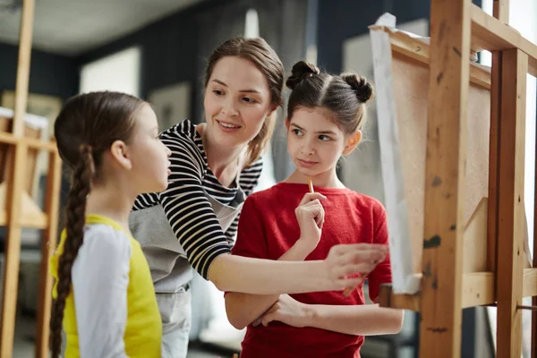 Zwei Schülerinnen Lauschen Beim Malen Den Erklärungen Des Lehrers — Stockfoto