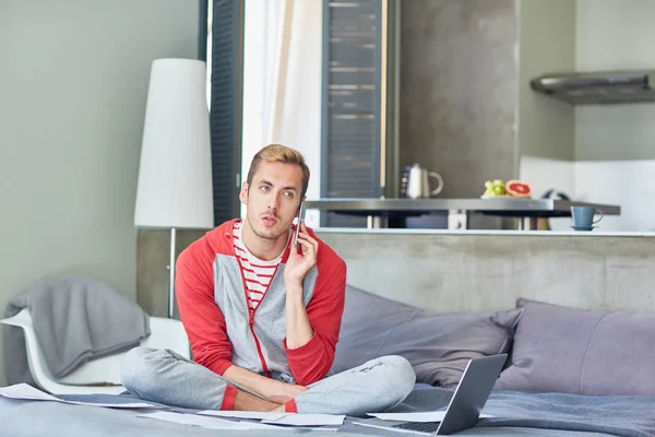 Jovem Homem Moderno Roupa Casa Falando Smartphone Enquanto Sentado Cama — Fotografia de Stock