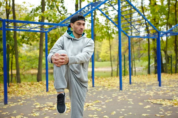 Sportos Fiatal Férfi Csinál Bemelegítő Gyakorlatain Miközben Őszi Park Festői — Stock Fotó