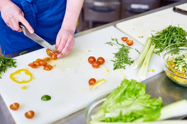 Specialist in cooking cutting fresh vegetables for healthy salad