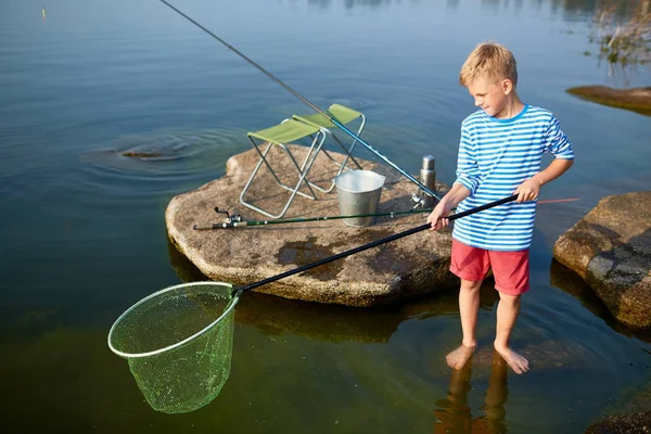 夏の湖の水だけで裸足純立っていると青いセーラー シャツ釣りを着て十代の金髪の少年の肖像画 — ストック写真