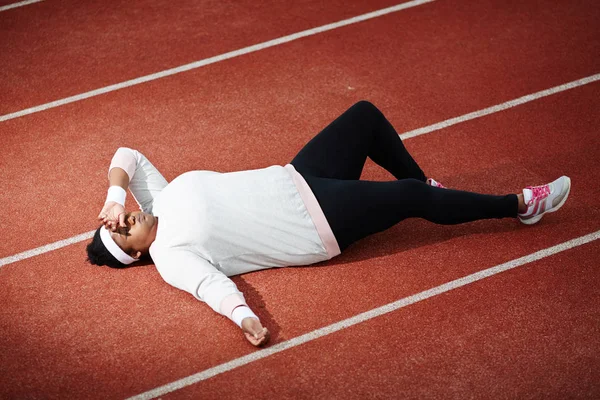 Изношенная Молодая Женщина Спортивной Одежде Лежит Ипподроме После Тяжелой Тренировки — стоковое фото