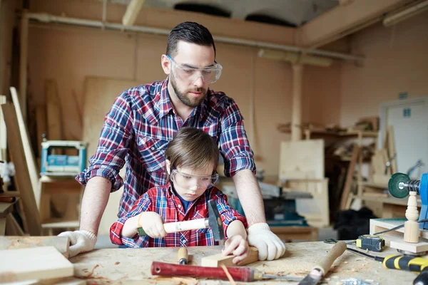 Jeune Homme Regardant Son Fils Marteler Clou Dans Atelier — Photo