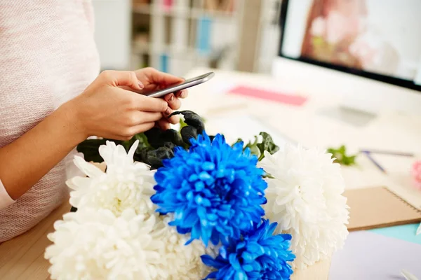 Unga Kvinnliga Florist Textning Smartphone Stående Träbord Med Vacker Bukett — Stockfoto