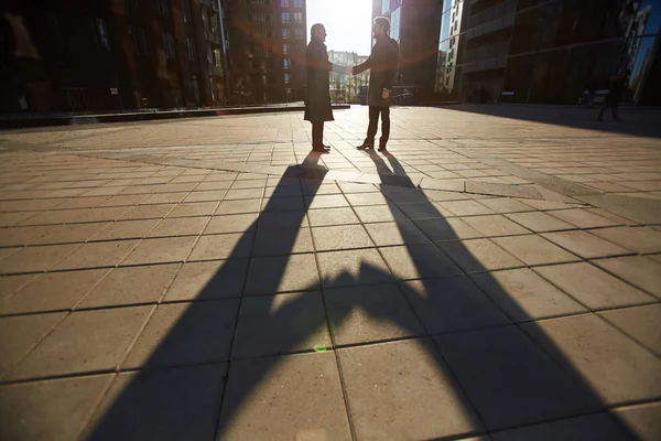 两个欢快的商业伙伴握手 而站在现代办公大楼 最后的光束设置太阳照亮他们 镜头耀斑 — 图库照片