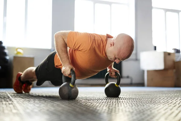 Skallig Bodybuilder Tittar Ner Med Koncentration Medan Gör Plankan Träning — Stockfoto