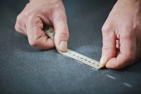 工作室的熟练裁缝的特写 在做衣服的时候手测量布料 — 图库照片