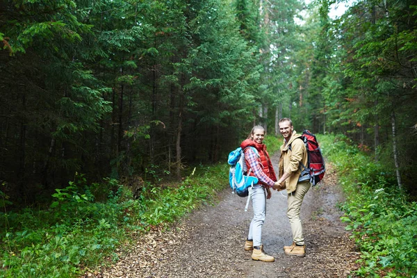 愉快的年轻夫妇与背包有旅行在森林在下雨天 — 图库照片