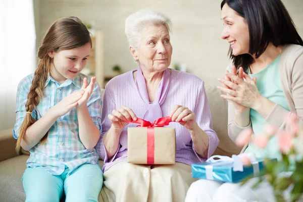 Seniorin Mit Gepacktem Geschenk Schaut Ihre Tochter Beim Händeklatschen — Stockfoto