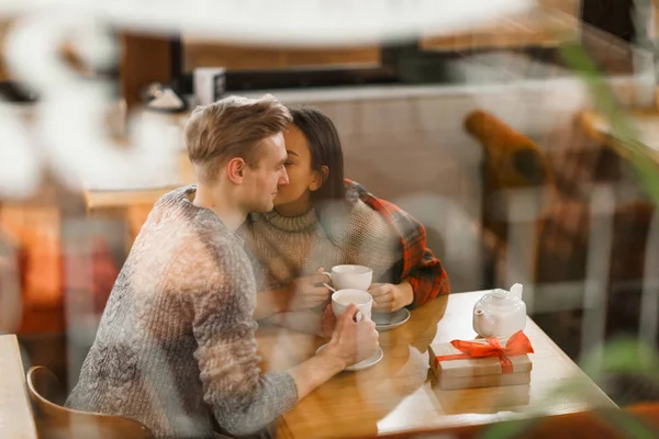 カフェでお茶をしながら頬にキスして彼氏好色な女の子 — ストック写真