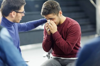 Dost psikolog gözyaşları içinde yalnız genç adam oturumu sırasında güven verici.