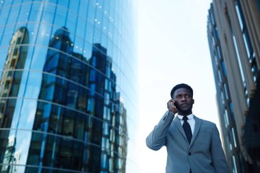 Kendine güvenen işadamı gökdelenler arka plan üzerinde arama