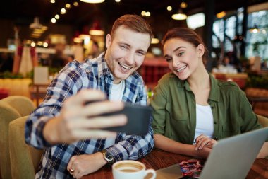 Güzel küçük kahvehane huzurlu akşam harcama arkadaş: onlar kokulu cappuccino ve kendilerini, bel, dikey alarak selfie zevk