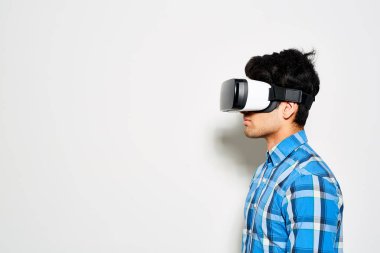 Beyaz arka plan, portre vurdu karşı dururken Vr gözlük kullanan kendine güvenen genç adam profil görünümü