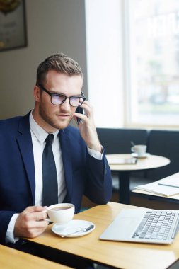 Çay tarafından smartphone cep telefonu ile konuşurken işadamı