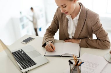 Genç muhasebeci notları not defterinde seminer için hazırlarken yapma