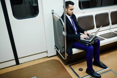 Metro Ortadoğu işadamı portresi tren dizüstü bilgisayar ile meşgul çalışma