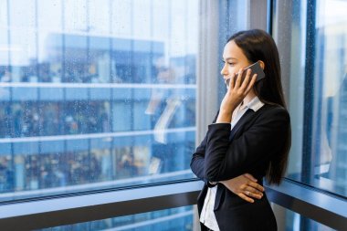 Panoramik pencereden, bel, dikey bakarken istemci ile sipariş ayrıntıları tartışıyor konsantre güzel Yöneticisi görünümünü profil