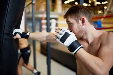 Genç sporcu spor salonunda boks torbası tekme