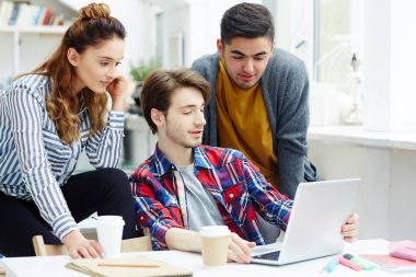 Grup projesi için fikirler tartışırken üniversite öğrencilerinin