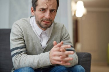 Özel Oda danışmanlık ve onun psikolog için bekleyen otururken kameraya bakarak çaresizlik içinde orta yaşlı adam portresi