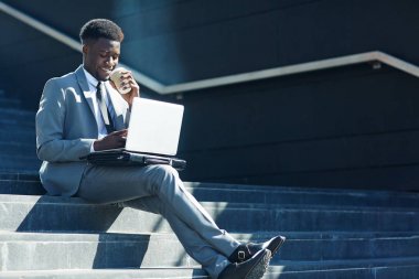 Profesyonel tüccar online merdiven açık havada üzerinde çalışırken içki içiyordum