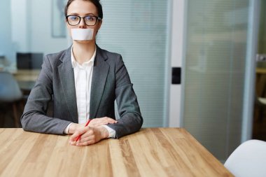 Voiceless busineswoman with her mouth stuck sitting by workplace clipart