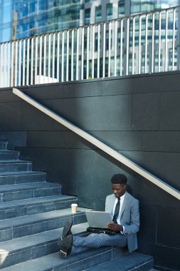 Kentsel ortamda merdiven üzerinde otururken ağ genç Yöneticisi