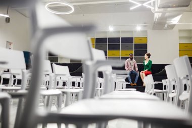 Genç grup tarafından konferans salonunda duvara oturan