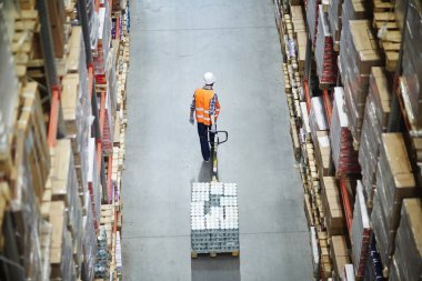 Koridor raf kutuları arasında hareket ederken forklift çekerek yükleyici