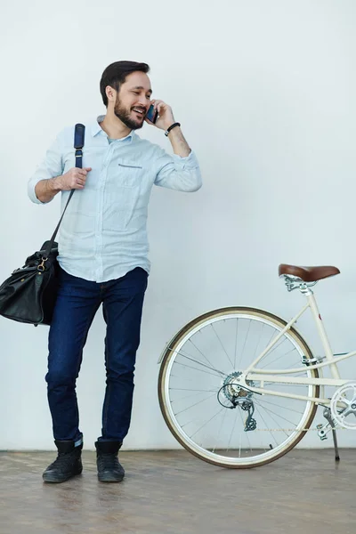 屋外自転車で壁に立って電話で話しモダンなアジア男の肖像 — ストック写真