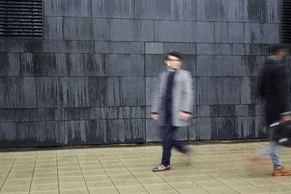 匆匆的人沿着现代建筑的黑墙走下 Trottoire — 图库照片