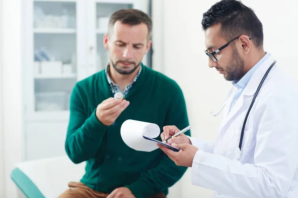 Självsäker Ung Läkare Glasögon Förskrivning Piller Till Medelålders Skäggiga Patient — Stockfoto